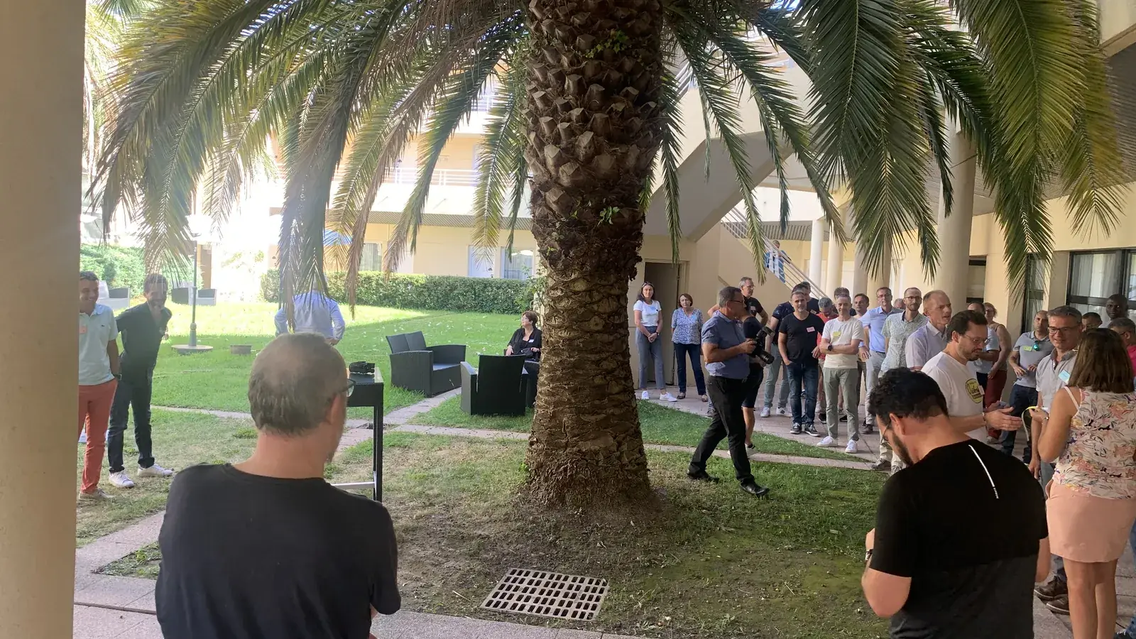 Les participants réunis dans le patio de l'hôtel, sous les palmiers